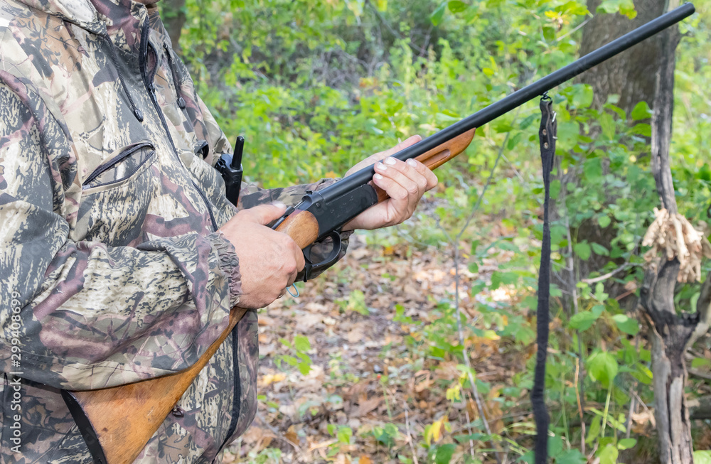 A man with a hunting rifle in his hands, loading a weapon.