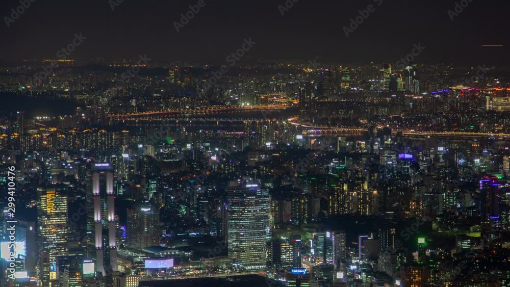 Timelapse flashing advertisements on large Seoul building displays among illuminated city with highways panning up Timelapse flashing advertisements on large Seoul building displays among illuminated city with highways panning up