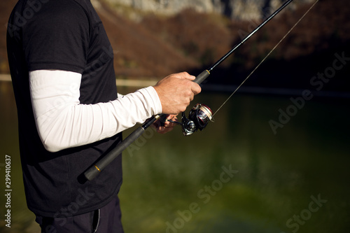 Fisherman holding rod and fishing at lake