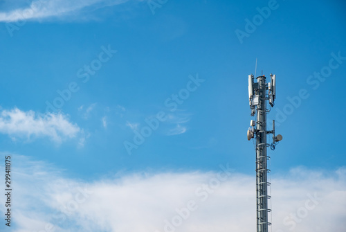 Cellular Base Station or Base Transceiver Station. Telecommunication tower. Wireless Communication Antenna Transmitter. 3G, 4G and 5G Cell Site with cloudy blue sky.