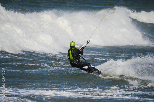 Kitesurfer at high speed cuts the waves. Stormy weather.