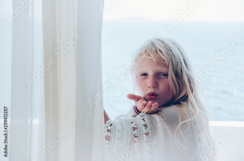 mysterious princess with long blond hair in the balcony low key effect sending imaginery kiss photo