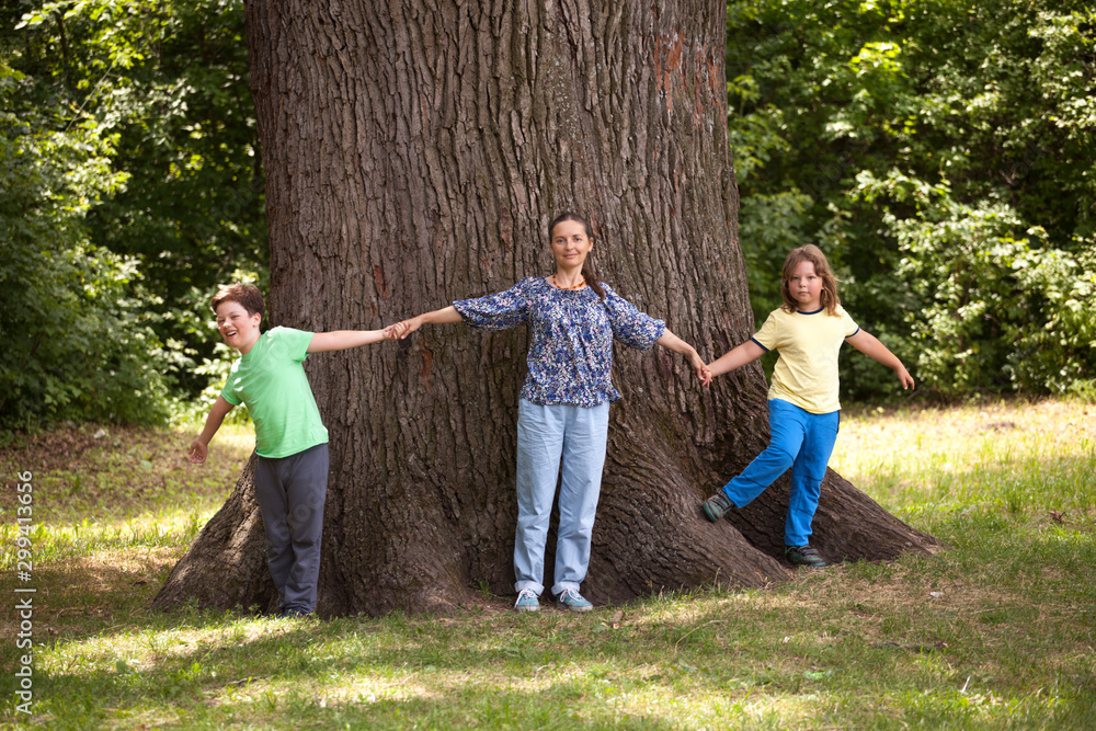 Fototapeta premium Family Hugging Big Tree, Boy and mother Embracing oak