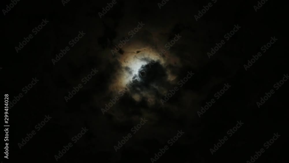 full moon shines behind moving clouds full moon shines behind moving clouds