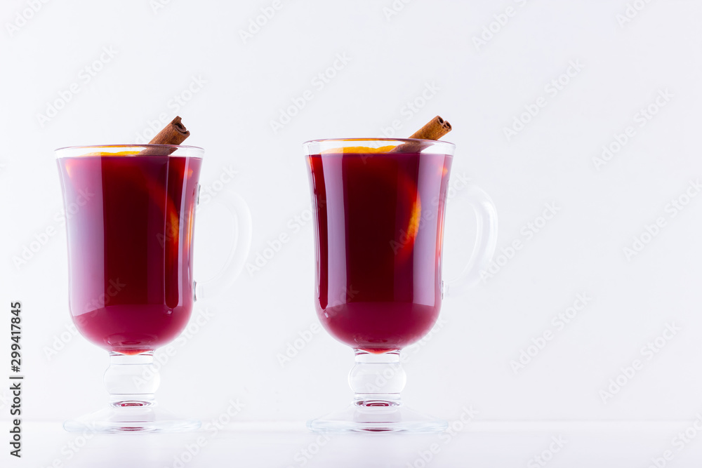 Glass of hot mulled wine with spices on white background. Christmas mulled wine with orange, star anise and cinnamon. Two glasses of winter Christmas drink Glass of hot mulled wine with spices on white background. Christmas mulled wine with orange, star anise and cinnamon. Two glasses of winter Christmas drink