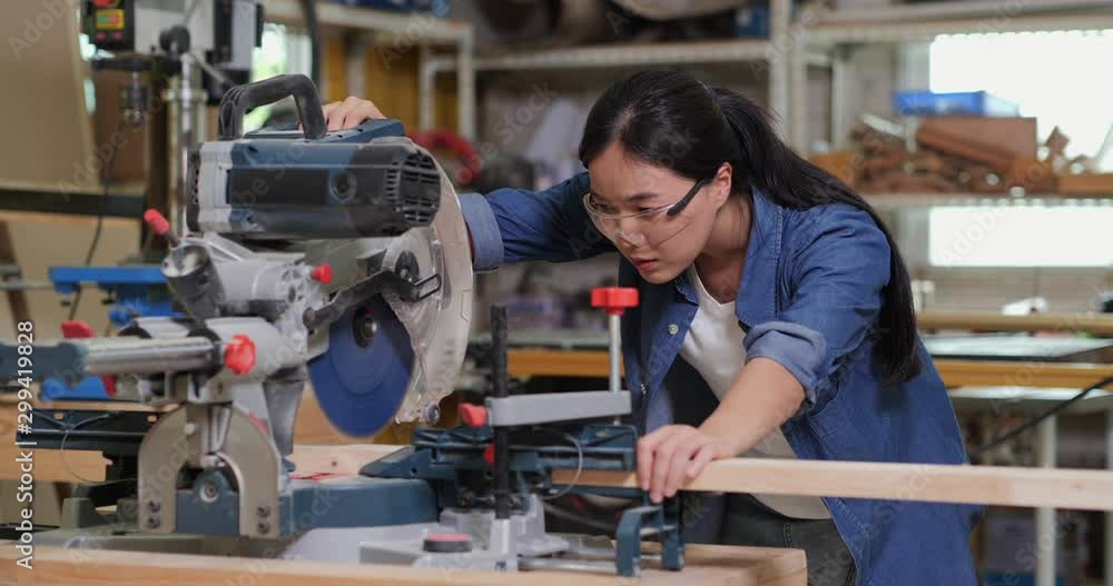 Attractive asian female carpenter using some power tools for her work in a woodshop. 4K Resolution Attractive asian female carpenter using some power tools for her work in a woodshop. 4K Resolution