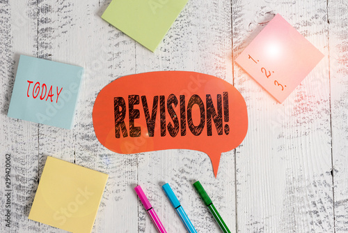 Text sign showing Revision. Business photo text action of revising over someone like auditing or accounting Ballpoints pens blank colored speech bubble sticky notes wooden background photo