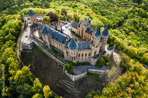 Aerial panorama of Burg Hohenzollern (Hohenzollern castle) with hills and villages surrounded by forests with beautiful foliage photo