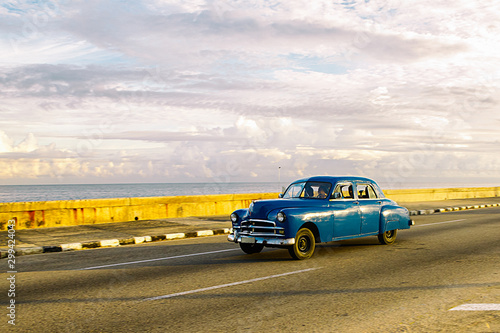 Blue car driving along the Malecon in Havana, Cuba