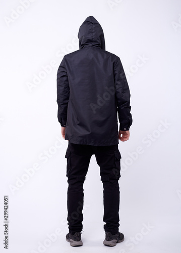 A man stand up wearing black jacket isolated white at the studio.