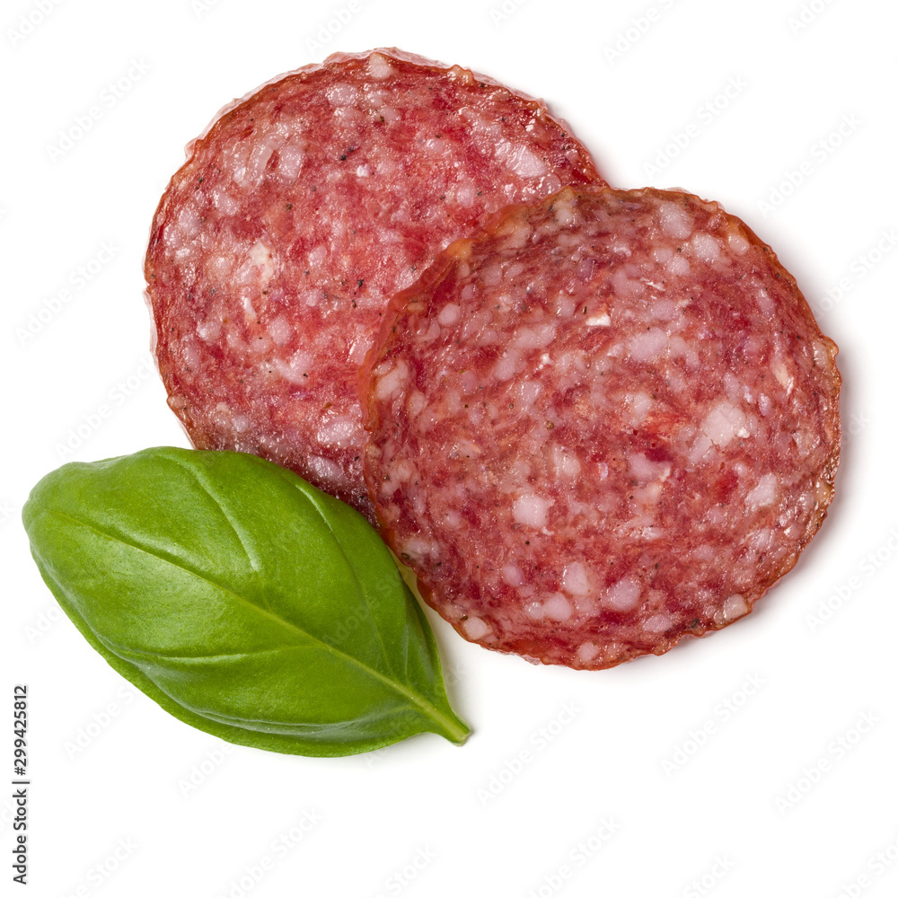 Slices of salami isolated over white background closeup. Sausage and basil leaves top view.. Slices of salami isolated over white background closeup. Sausage and basil leaves top view..