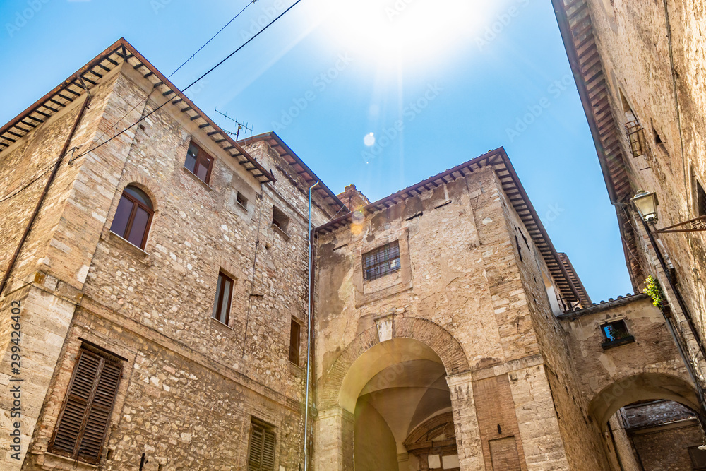 A characteristic glimpse in the ancient medieval village of Narni. Umbria, Terni, Italy. Old stone and brick buildings.The blue sky on a summer day. Abridge and arch.