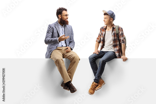 Teacher talking to a male student sitting on a panel