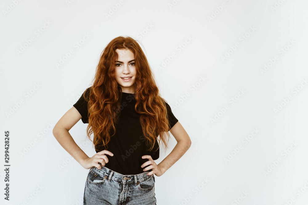 schoolgirl with her hair standing with her hands on her hips. bright studio schoolgirl with her hair standing with her hands on her hips. bright studio