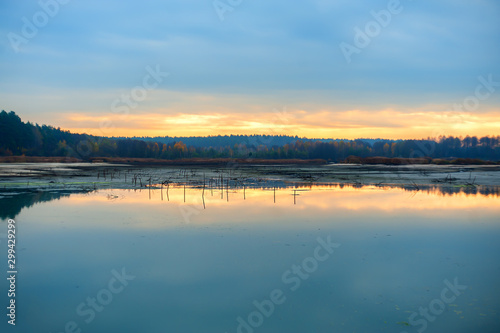 Gloomy morning  sunrise and dark blue skies on half-dry lake  panoramic image