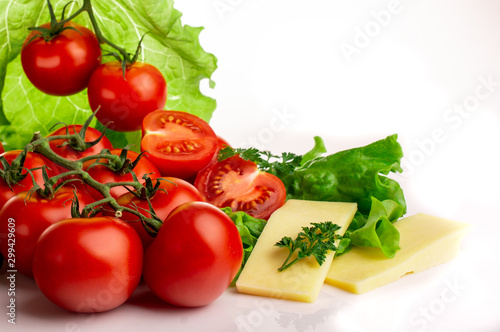 ripe tomatoes with lettuce leaves on a white background