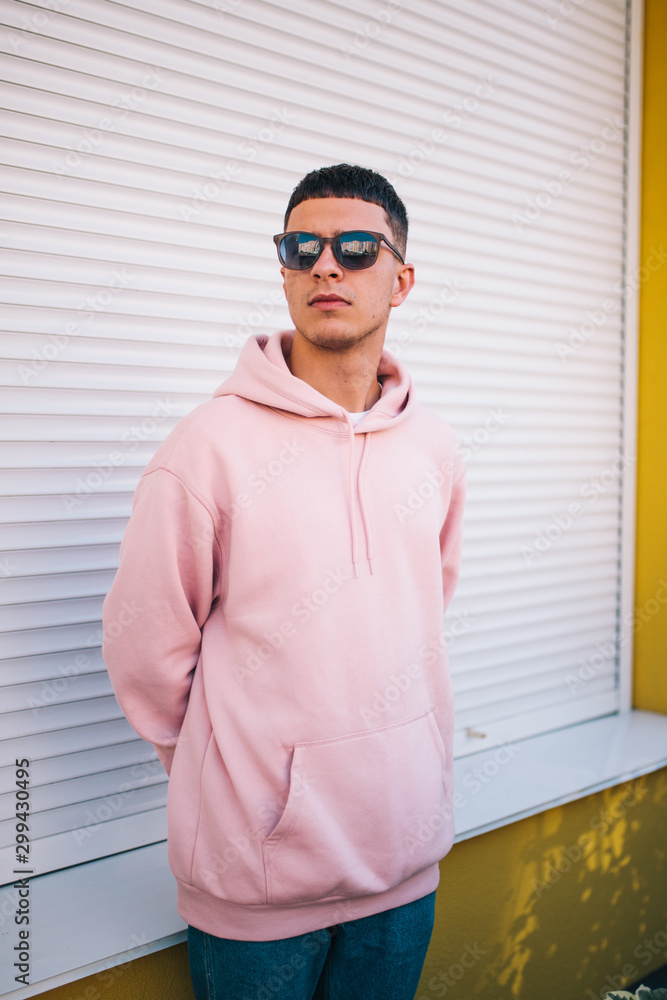 City portrait of handsome hipster guy wearing pink blank hoodie or hoody with space for your logo or design. Mockup for print City portrait of handsome hipster guy wearing pink blank hoodie or hoody with space for your logo or design. Mockup for print