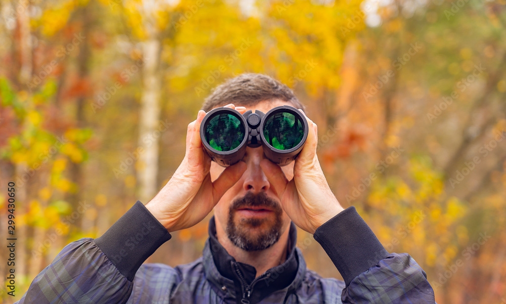 man with binoculars. autumn forest background. man with binoculars. autumn forest background.
