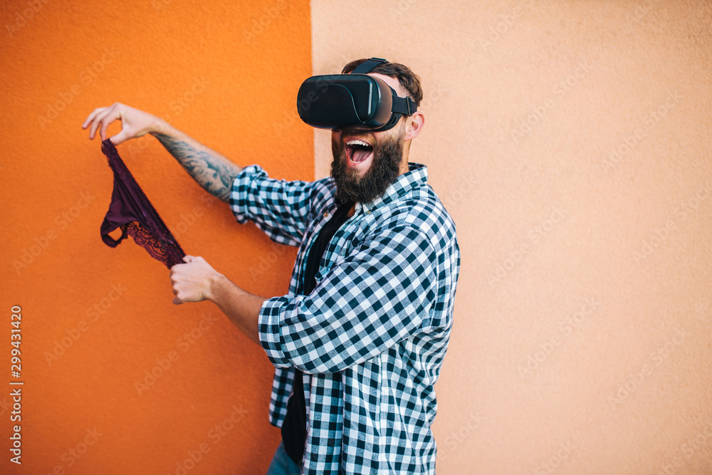 Virtual sex concept. Man in VR glasses play cybersex games and holding  female panties in his hands. Stock Photo | Adobe Stock