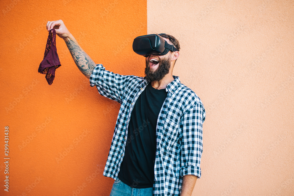 Virtual sex concept. Man in VR glasses play cybersex games and holding  female panties in his hands. foto de Stock | Adobe Stock