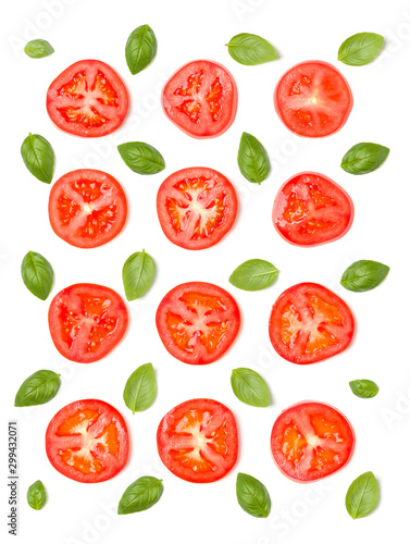 Creative layout made of tomato slices and basil leaves. Flat lay, top view. Vegetables isolated on white background. Food ingredient pattern.