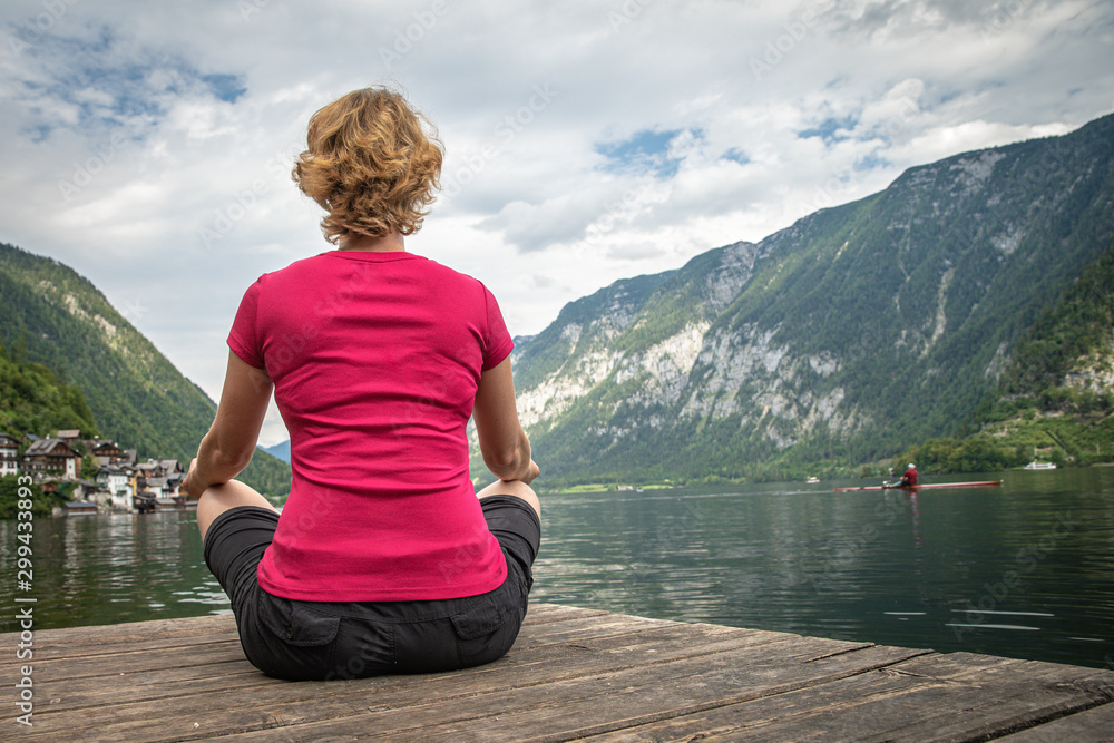 A young woman relaxes with a view of a mountain lake after a busy hike A young woman relaxes with a view of a mountain lake after a busy hike