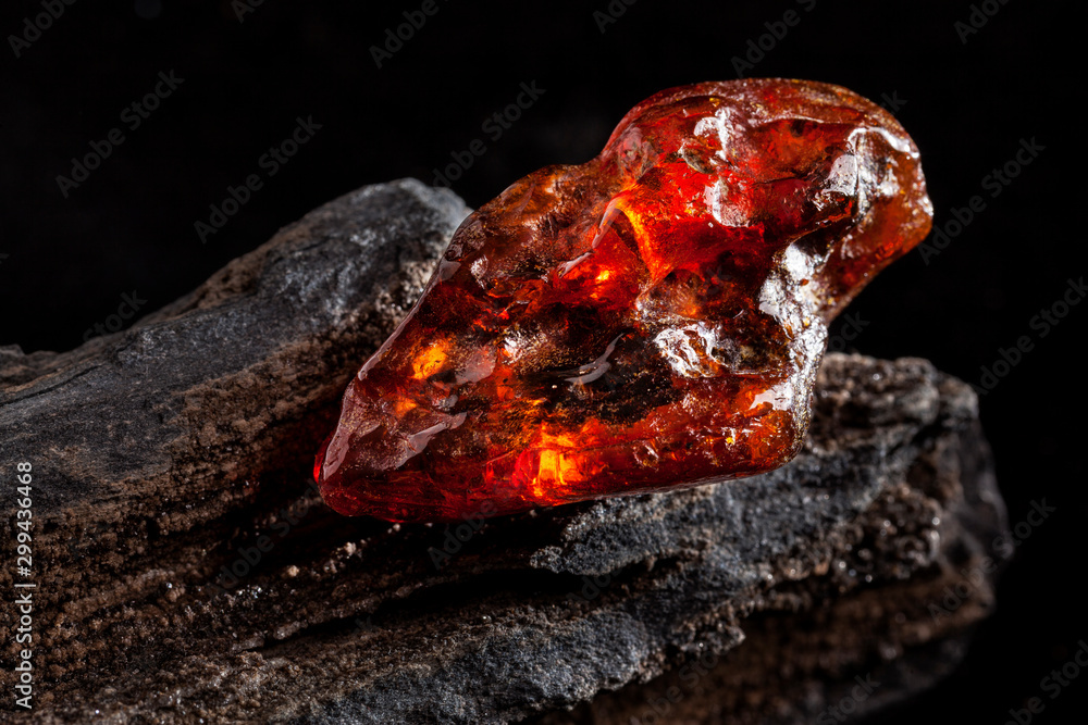 Natural amber. A piece of yellow and red semi transparent natural amber on piece of stoned wood. Natural amber. A piece of yellow and red semi transparent natural amber on piece of stoned wood.