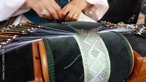 A close up of a woman disguised as 18th century attire and working on some ancient and traditional equipment during 18th century event in Montreal, Quebec, Canada.