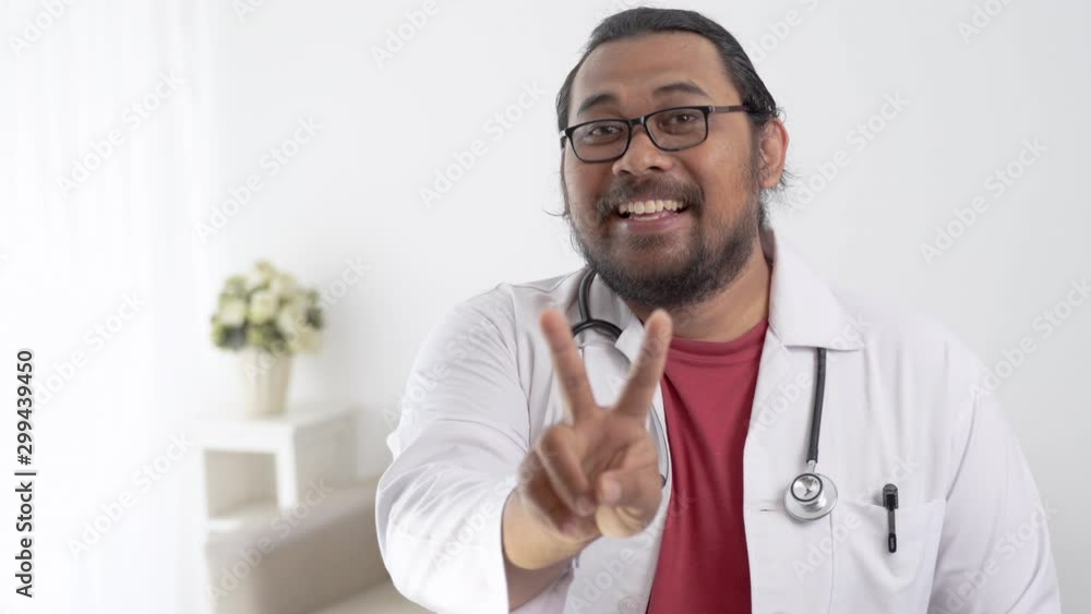 finger gesture doctor showing two sign or peace and looking at camera finger gesture doctor showing two sign or peace and looking at camera