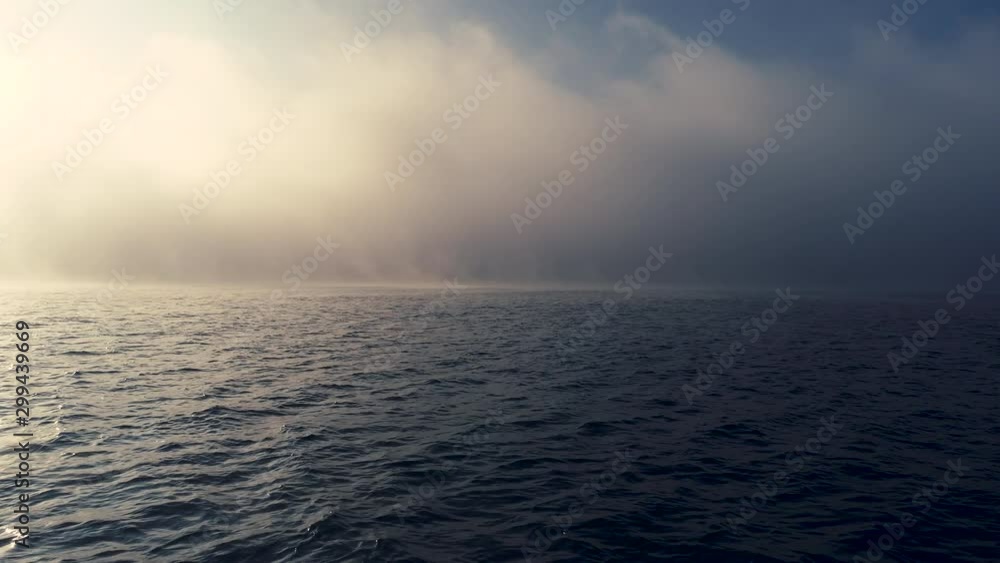 Sea sunrise and foggy morning. Fog above blue ripple water, aerial view Sea sunrise and foggy morning. Fog above blue ripple water, aerial view