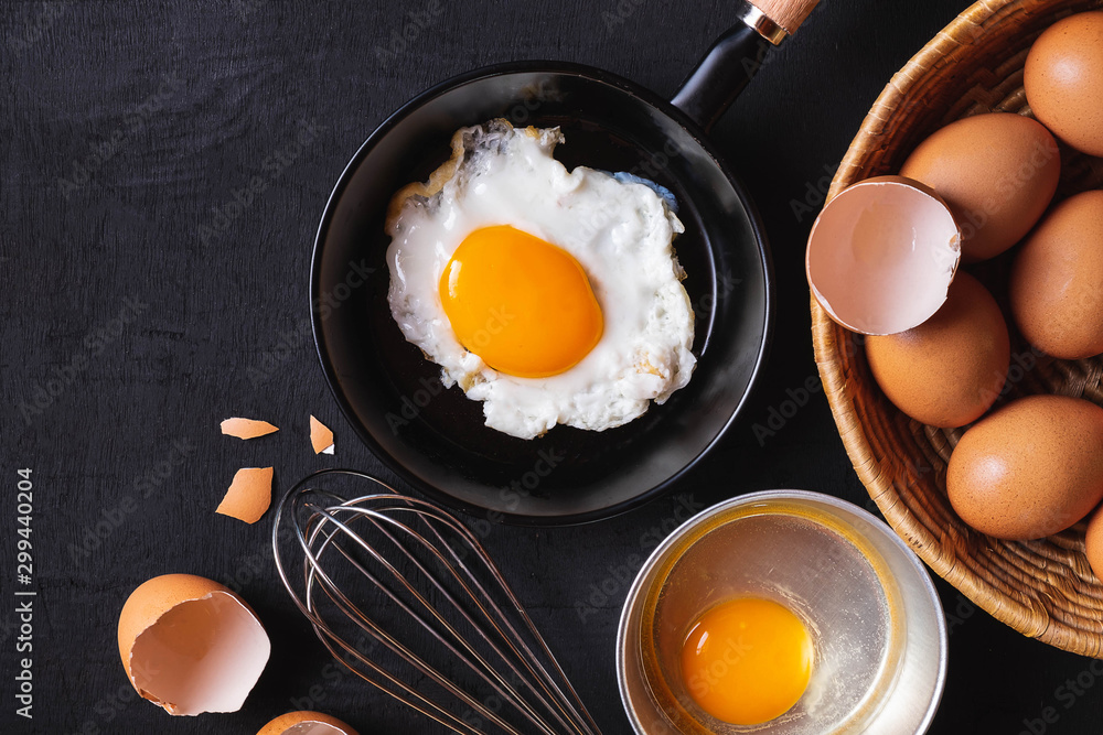 Frying pan in eggs and raw eggs on background Frying pan in eggs and raw eggs on background