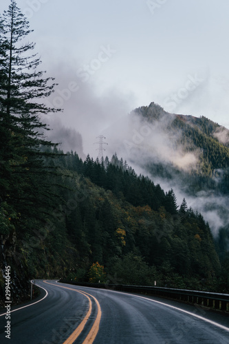 Open Road leading to nature and the mountains with fog