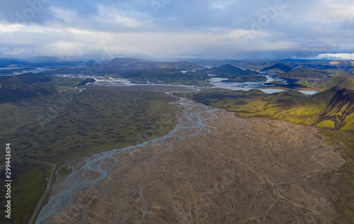 Iceland in september 2019. Great Valley Park Landmannalaugar, surrounded by mountains of rhyolite and unmelted snow. In the valley built large camp. The concept of world tours. Aerial drone shot.