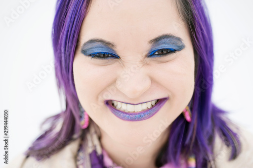 Happy modern woman with a big smile and purple hair. 