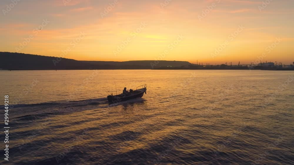 Dramatic sunset over the sea and silhouette of sailing speedboat Dramatic sunset over the sea and silhouette of sailing speedboat