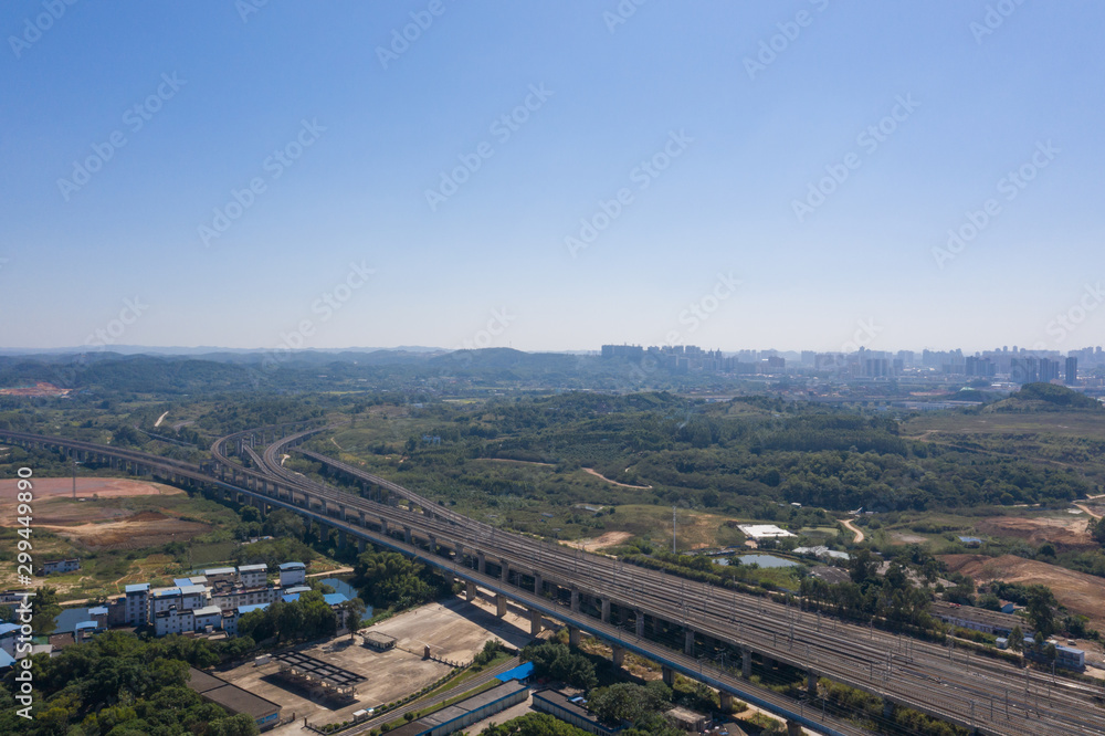 Aerial shot of curved railway ground and sky landscape over city suburbs
