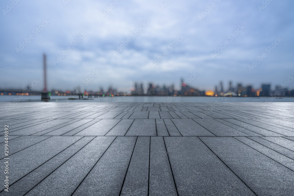 night view of empty brick floor front of modern blurred building