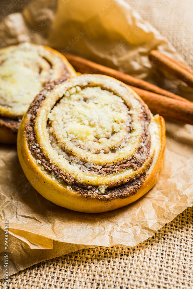 Fresh cinnamon buns on the rustic wooden background. Selective focus. Shallow depth of field.