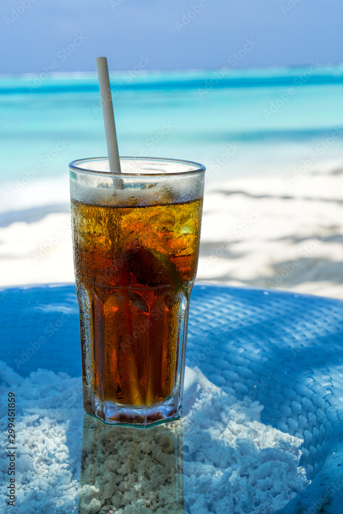 A glass of cold cocktail on a table on the beach in a restaurant A glass of cold cocktail on a table on the beach in a restaurant
