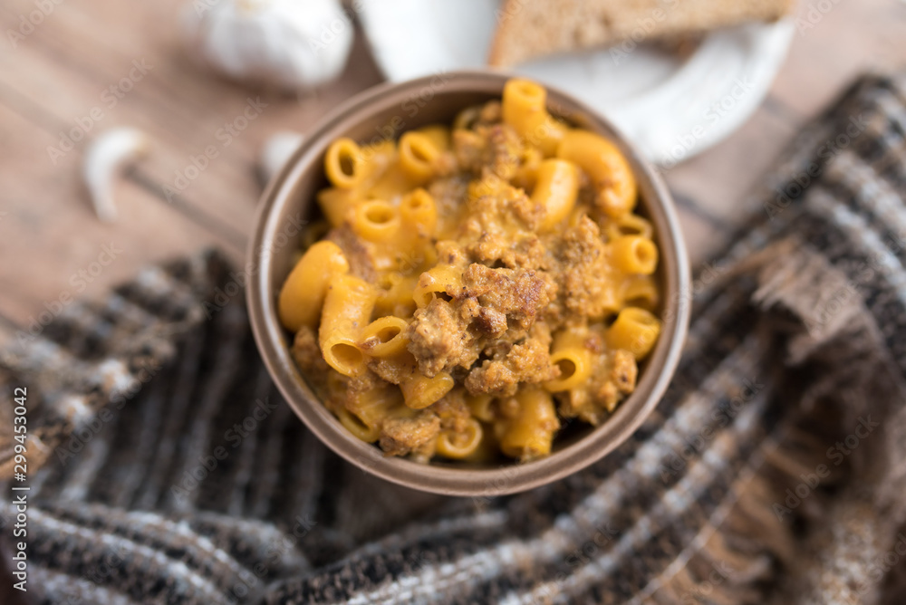 Homemade Cheeseburger Macaroni and cheese served in a small brown bowl made with ground turkey Homemade Cheeseburger Macaroni and cheese served in a small brown bowl made with ground turkey
