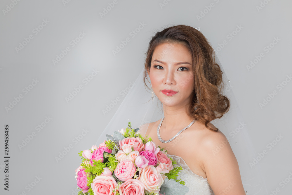 Naklejka premium Asian bride standing and holding a bouquet..