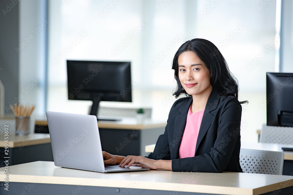 Asian businesswoman using laptop in office.. Asian businesswoman using laptop in office..