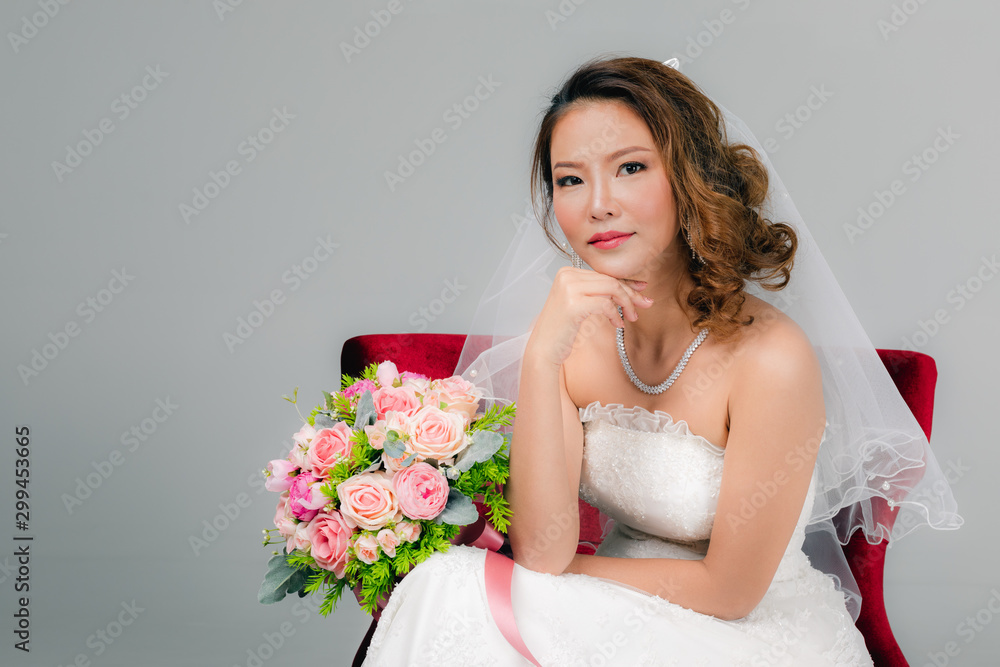 Asian bride sitting and holding a bouquet.. Asian bride sitting and holding a bouquet..