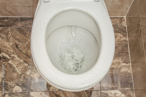 Flushing the toilet. A strong whirlpool of water in the toilet.