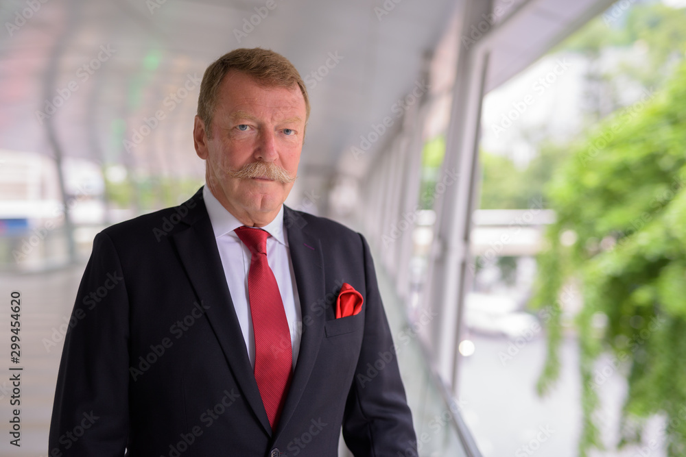 Handsome senior businessman with mustache exploring the city Handsome senior businessman with mustache exploring the city