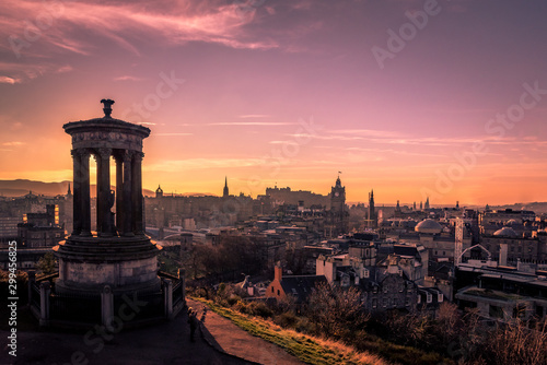 EDINBURGH, SCOTLAND DECEMBER 14, 2018: Beautiful sunset at the Dugald Stewart Monument in the foreground with central Edinburgh cityscape behind including Edinburgh Castle and North Bridge
