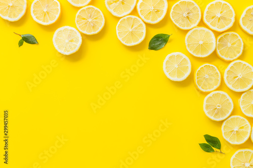 Fruit frame. Lemons and leaves on yellow background top view space for text