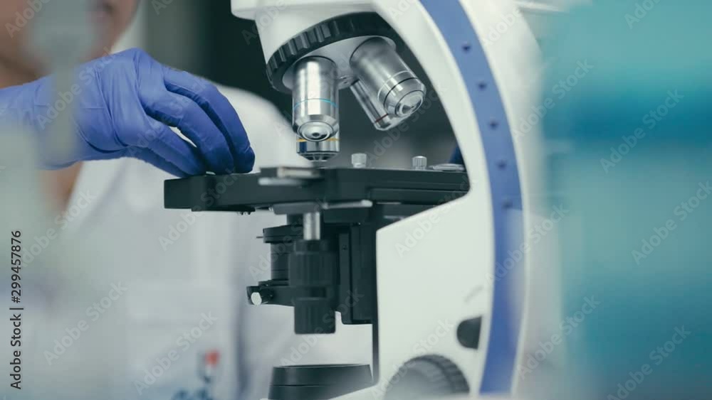 Scene slow motion of scientist is using with microscope in bio laboratory, Scientist using microscope in laboratory to study sample. DNA Scene slow motion of scientist is using with microscope in bio laboratory, Scientist using microscope in laboratory to study sample. DNA