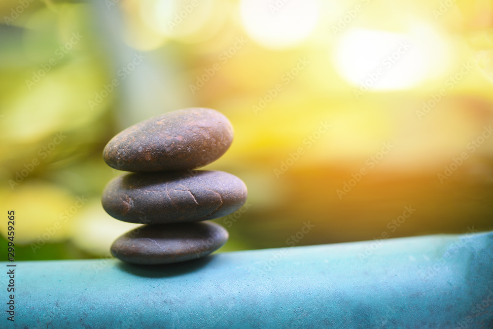 Obraz premium Natural wellness concept - Relax zen stones stack on wooden nature green background Spa Natural Alternative Therapy With Massage Stones