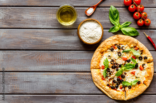 Traditional italian food: pizza on dark wooden background top view copy space